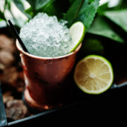 cocktail alcoolico com gelo e limao em bronze pode copo na mesa de bar
