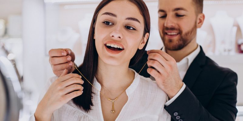 young couple choosing a necklace at jewelry store