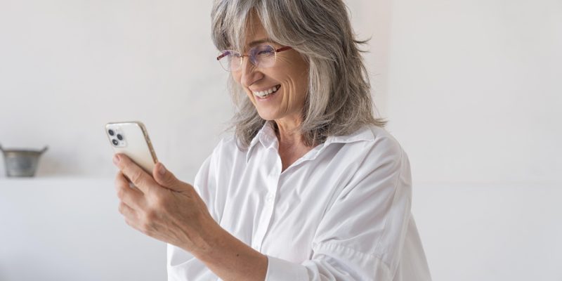 portrait older woman using smartphone device